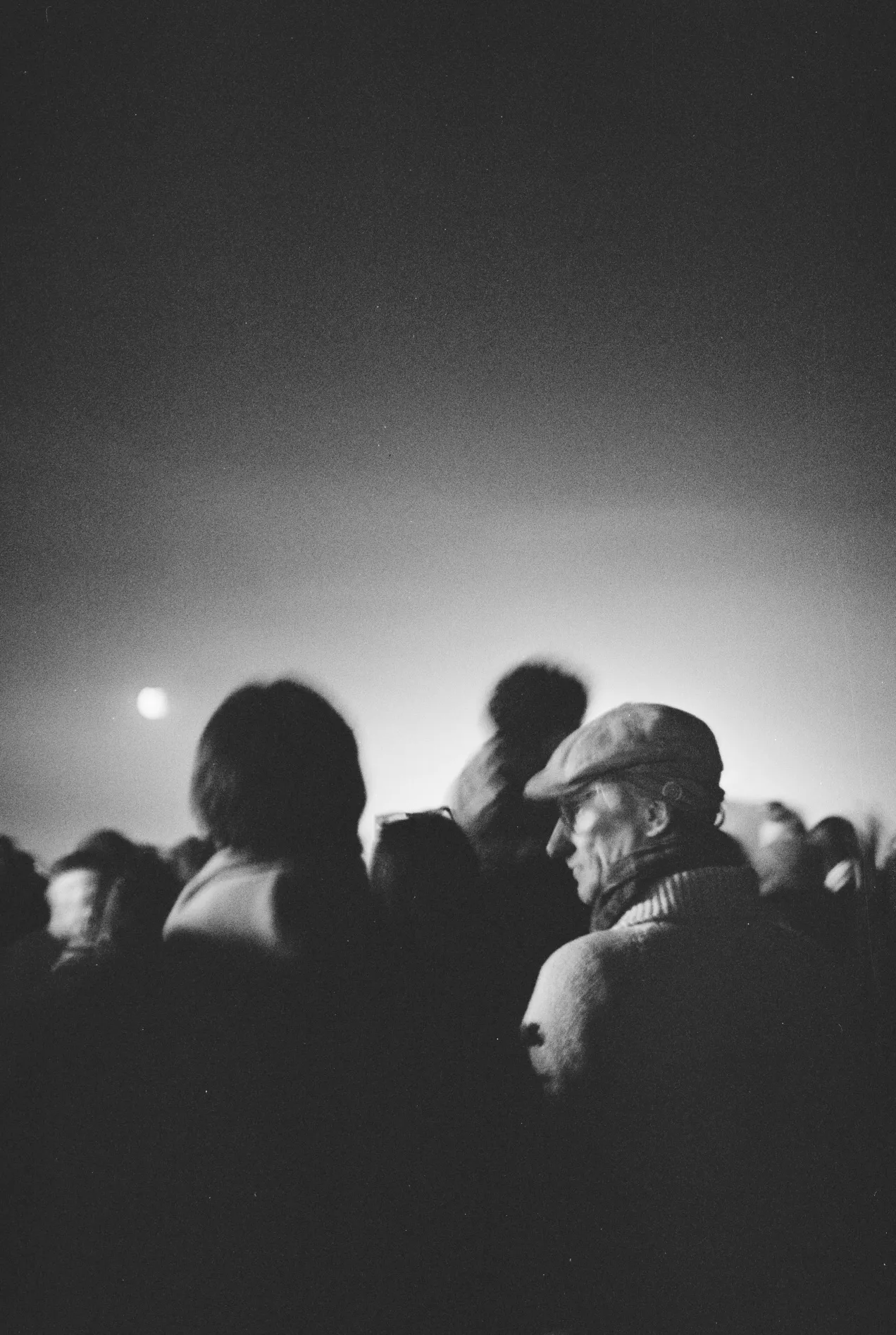 moonlit man amongst people, looking