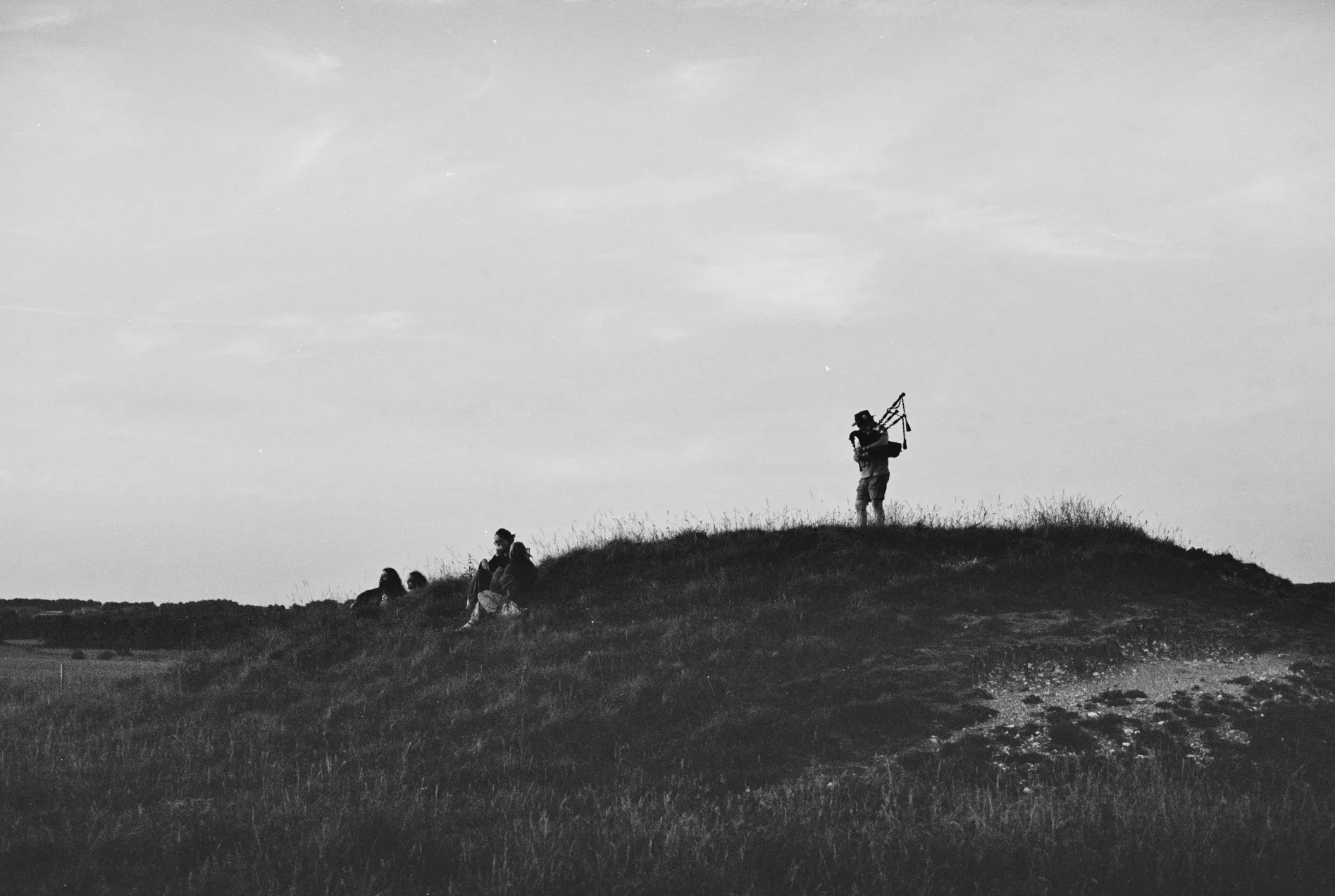 person playing bagpipes on the hill